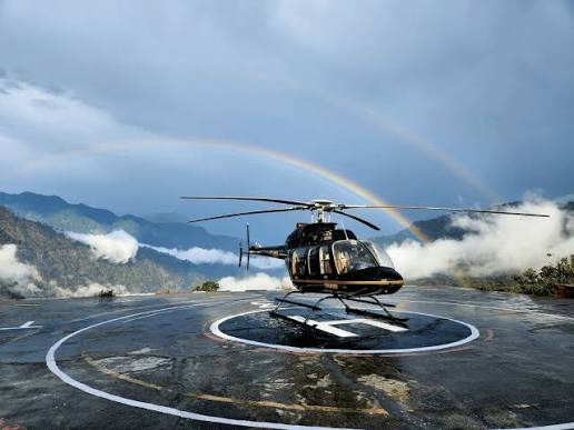 Helicopter with rainbow over the Himalayas